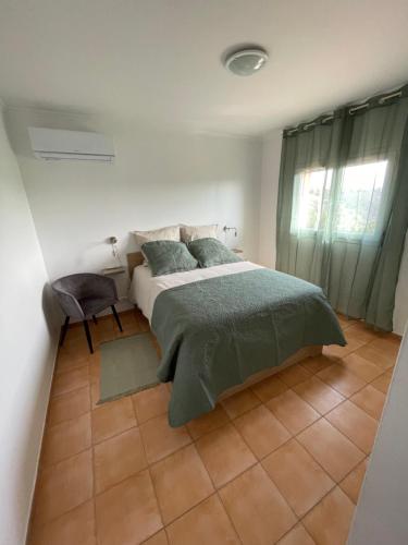 une chambre avec un lit et une chaise dedans dans l'établissement Villa Saveur Nature, à Cagnes-sur-Mer