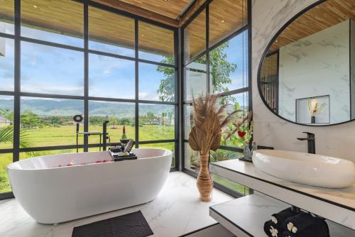 Un baño con dos lavabos y una gran ventana. en Villa Sea View Beach Estate, en Buleleng