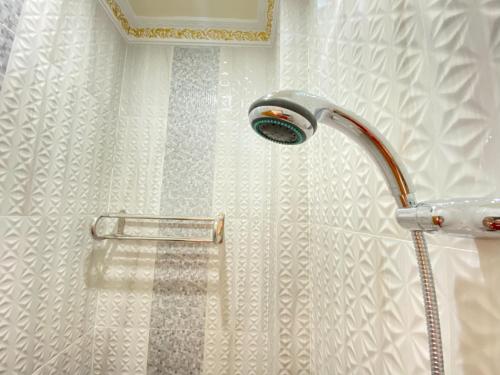 La salle de bains est pourvue d'une douche avec un pommeau de douche. dans l'établissement Rumah Windy Guest House Bira, à Bira