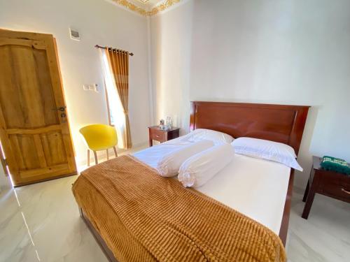 a bedroom with a large bed with a wooden headboard at Rumah Windy Guest House Bira in Bira