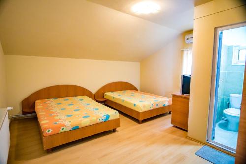 2 łóżka w małym pokoju z łazienką w obiekcie Casa Bibi w mieście 2 Mai