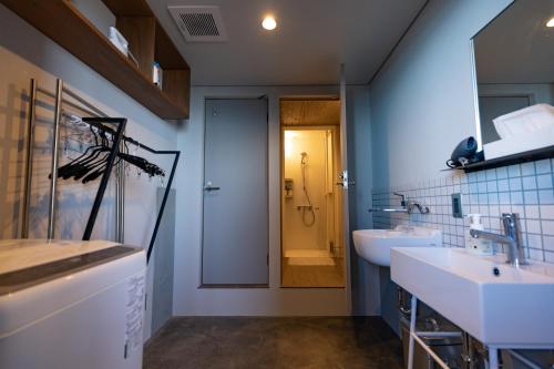 ein Bad mit 2 Waschbecken und einer ebenerdigen Dusche in der Unterkunft ゲストハウス＆カフェ　ハレテル in Masuda