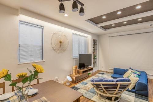 a living room with a blue couch and a tv at self-check in-House,Ueno sky tree area, free wifi 3LDK in Tokyo