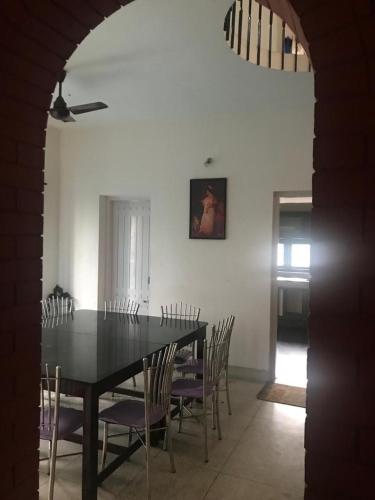 a dining room with a black table and chairs at Deshadan Duplex homes in Trivandrum