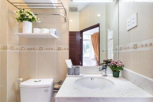 uma casa de banho com um lavatório, um WC e um espelho. em Cabana Hotel - 47A Nguyen Trai, Q1 - by Bay Luxury em Ho Chi Minh