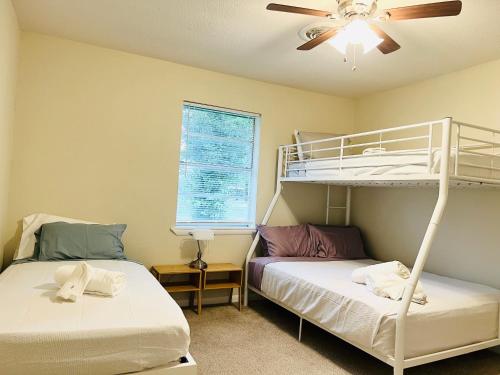 a bedroom with two bunk beds and a ceiling fan at The Lil' Yellow Door8 in Durant