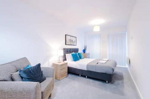 a bedroom with a bed and a couch at Spacious 2-Bedroom Apartment in the Heart of Manchester - Ideal for Families or Groups in Manchester