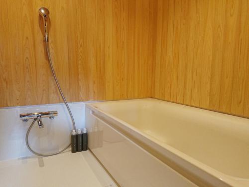 a bathroom with a bath tub with a shower at NIPPONIA Izumo Taisha Shrine Town in Izumo