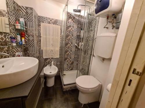 ein Bad mit einem Waschbecken, einem WC und einer Dusche in der Unterkunft Historic house close to station in Genua