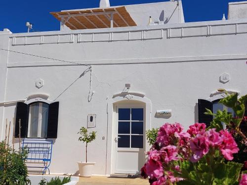 a white house with pink flowers in front of it at "Casa Oliveiras" studio avec terrasse et piscine in Loulé