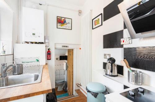 una pequeña cocina con lavabo y aseo en Nice bedroom close to the train station and the city centre, en Norwich