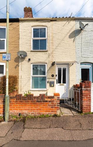a brick house with a white door and windows at Nice bedroom close to the train station and the city centre in Norwich