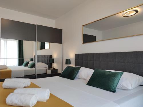 sypialnia z 2 łóżkami i dużym lustrem w obiekcie Villa ARIA with a private heated pool w mieście Debeljak