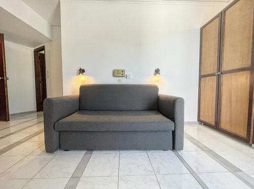 a couch in a room with two lights on the wall at Pal Beach in Palaiochóra