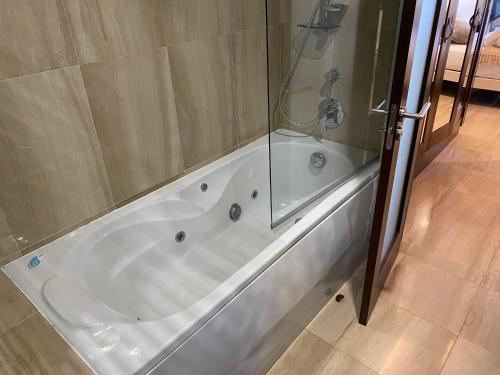 a bath tub with a shower and a glass wall at Apartamento lujo en primera línea de playa en Bahía de la Plata, Estepona in Estepona