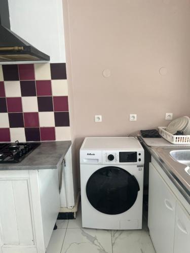 a kitchen with a white dishwasher and a sink at Room in Calais