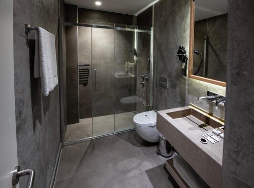 y baño con ducha, aseo y lavamanos. en Hotel Bosfora, en Estambul