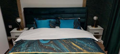 sypialnia z dużym łóżkiem z niebieskimi poduszkami w obiekcie Lux Apartmani Novi Park w mieście Vrdnik