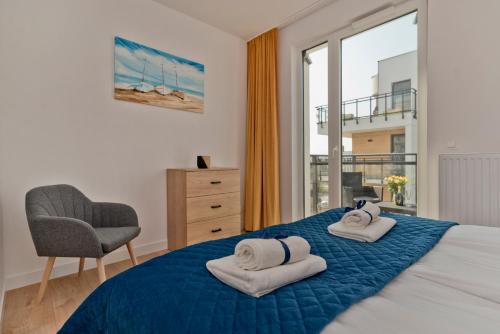 sypialnia z łóżkiem, krzesłem i oknem w obiekcie BlueApart Apartamenty Hotelowe Nexo II w mieście Puck