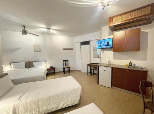 a hotel room with two beds and a flat screen tv at Pal Beach in Palaiochora