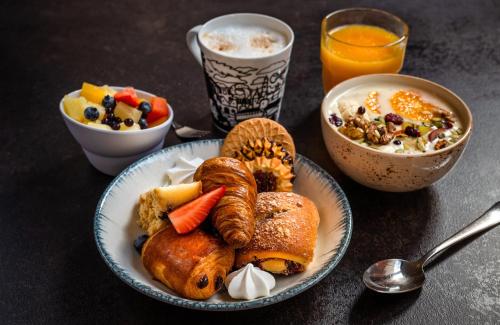 einen Tisch mit einem Frühstücksteller und einem Glas Orangensaft in der Unterkunft Leonardo Boutique Hotel Krakow Old Town in Krakau