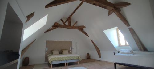 een zolderkamer met een bed en een raam bij La Demeure de l'Aubance in Saint-Mélaine-sur-Aubance