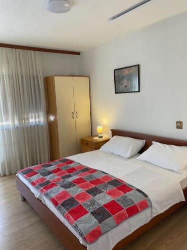 a bedroom with a bed with a red and black quilt at Palada House with a Private Pool in Marina