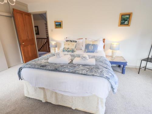 a bedroom with a large bed with two pillows at Rawfell in Ambleside