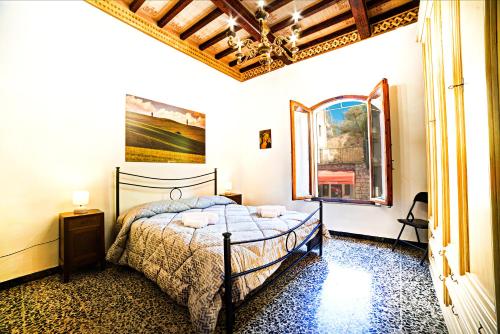 a bedroom with a bed and a chandelier at La casa di Giulina in Siena