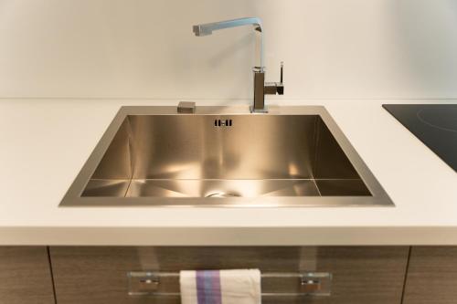 a stainless steel sink in a white kitchen at 15min metro Duomo - RHO fiera - Skyscraper Kitchen in Milan