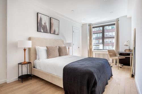 a bedroom with a bed and a desk and a window at Midtown East 1br w gym wd nr Grand Central NYC-1108 in New York