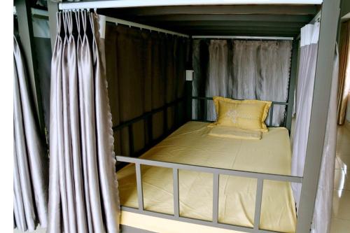 een klein bed in een kamer met een gordijn bij Ninh Bình City Backpackers Hostel in Ninh Binh