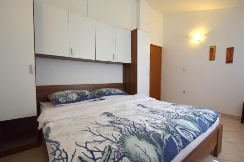 a bedroom with a large bed with blue and white sheets at Holiday Home Pere in Malinska