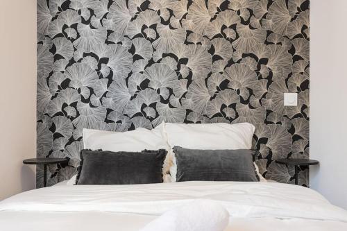 1 dormitorio con 1 cama con papel pintado en blanco y negro en Le doux nid - Résidence Hestia en Saint-Étienne