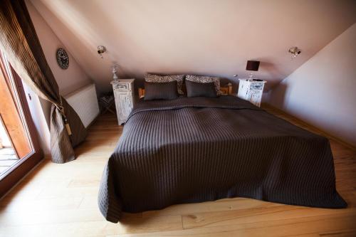 a bedroom with a large bed with a black comforter at Rancho Zapotoczny in Łagów