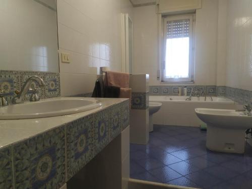 y baño con 2 lavabos, bañera y aseo. en Nel Giardino Fiorito en Salerno