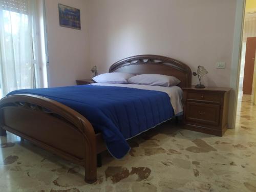 a bedroom with a large bed with a blue blanket at Nel Giardino Fiorito in Salerno