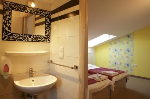 a bathroom with a sink and a mirror at Hotel Villa Sandi - free parking in Čavle