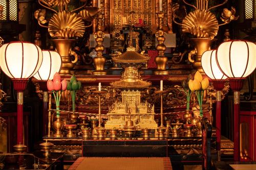 a room with a altar with flowers and lamps at Yochi-in in Koyasan
