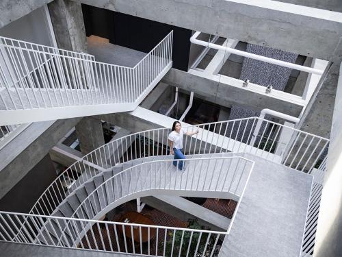 une femme debout sur un escalier dans un bâtiment dans l'établissement SHIROIYA HOTEL, à Maebashi