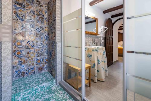 a bathroom with a shower with blue and white tiles at La Corteccia del Faggio in Abbadia San Salvatore