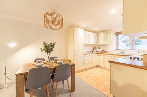 cocina y comedor con mesa de madera y sillas en Harmonious 2Bed Apartment-Suits Contractors en Leeds