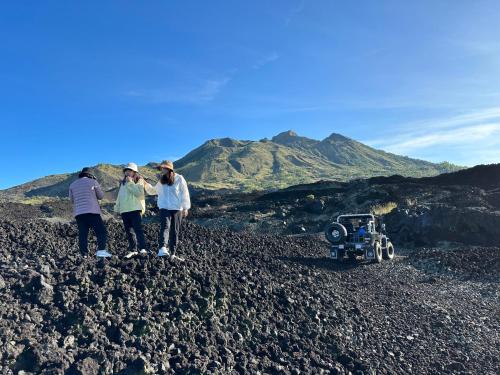 a group of three people standing on a rocky mountain at The Lava Bali Villa and Hot Spring in Kintamani