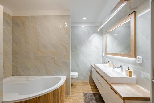 ein Badezimmer mit einer Badewanne, einem Waschbecken und einem WC in der Unterkunft REZIDENCE PODĚBRADY in Poděbrady