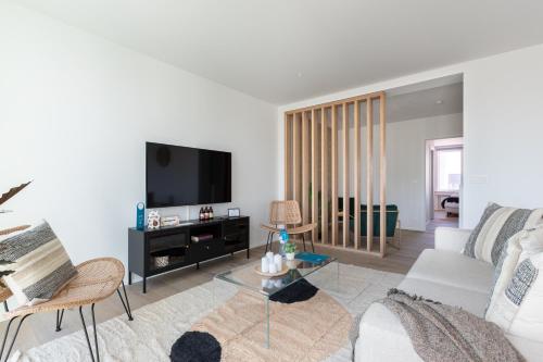 a living room with a couch and a tv at Sweet Inn - De Brouckere in Brussels