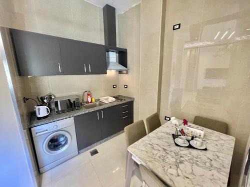a kitchen with a table and a washing machine at Villa Mira GuestHouse 2 - Downtown Central Amman - AL DIYRIH in Amman