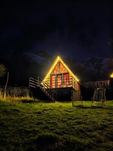 une cabine avec des lumières sur son côté la nuit dans l'établissement Kazbegi Kuro Cottages, à Kazbegi