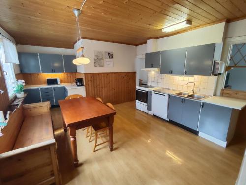 a kitchen with blue cabinets and a wooden table at Living Ludvika in Ludvika