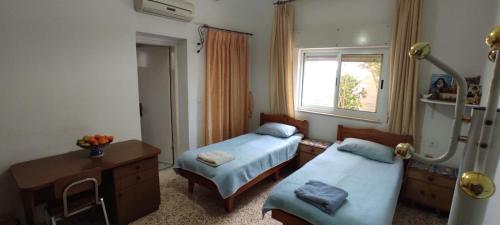 um quarto de hospital com duas camas e uma janela em Reema's House em Bayt Sāḩūr