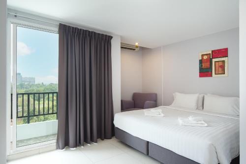 a bedroom with a bed and a large window at The Riche Boutique Hotel Don Mueang Airport in Bangkok